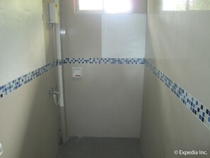 A small, enclosed shower area with a handheld showerhead, a soap dispenser, and a tiled floor. - B n T Inn (Lapu-Lapu)
