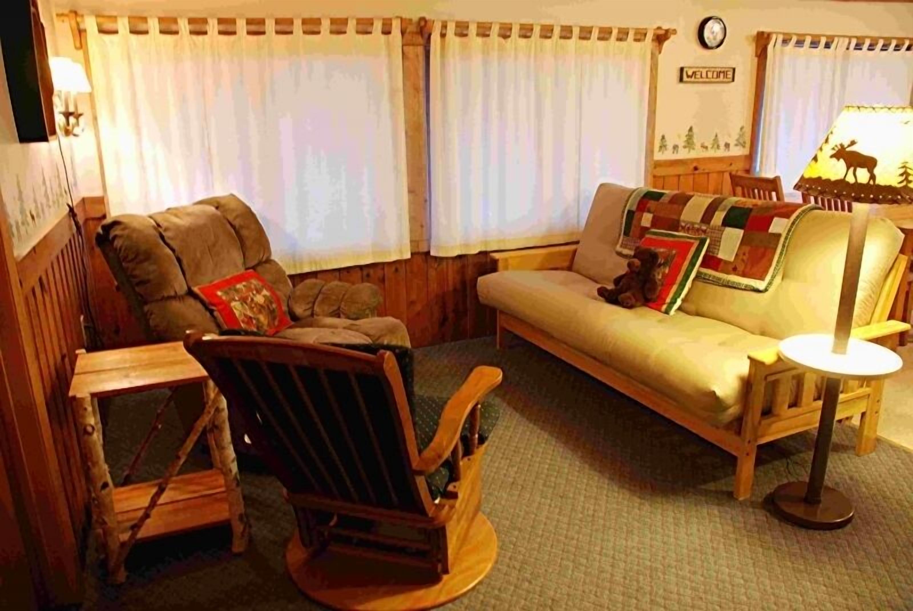 A cozy living room with a sofa, a rocking chair, and a small table.