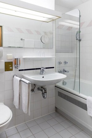 A modern bathroom with a white sink, a glass shower enclosure, and a toilet. - Hotel St. Georg Gmbh (Bad Aibling)