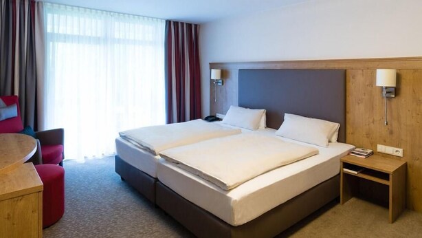 Una habitación de hotel con una cama grande, un escritorio y una silla.