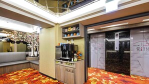 A hotel lobby with a seating area, a coffee station, and an elevator. - Hotel I Journey (Taipei)