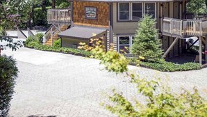 A lodge with a wooden exterior, a balcony, and a staircase leading to the upper level. - Brook Trout Inn (Sapphire)
