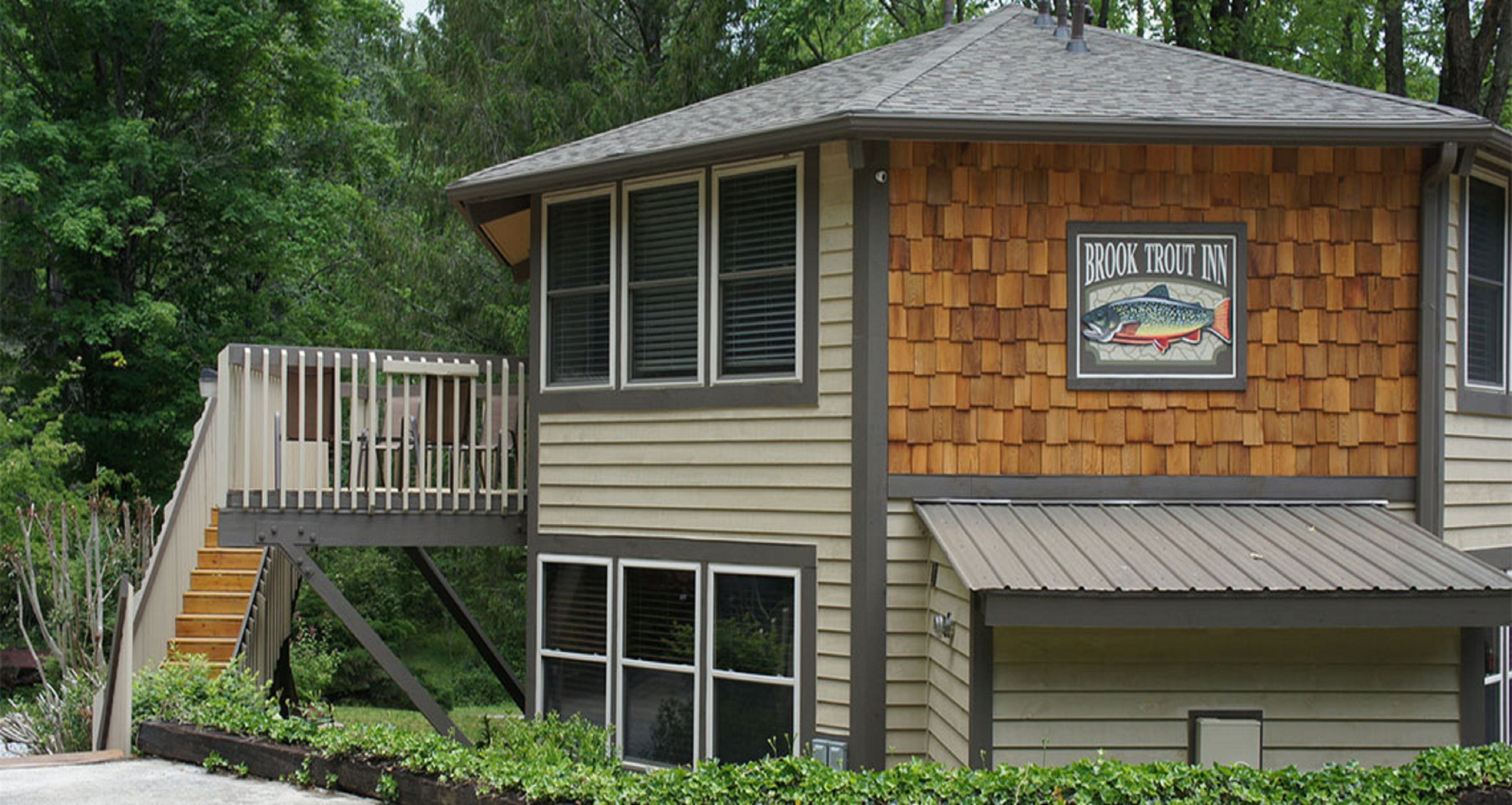 A building with a wooden exterior and a sign that reads "Brook Trout Inn."