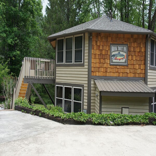 A two-story building with a wooden facade and a sign for 'Brook Trout Inn'.