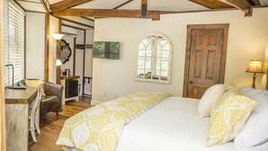 A bedroom with a bed, a desk, a chair, a window, and a door. - Brook Trout Inn (Sapphire)