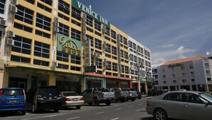Un edificio de varios pisos con un letrero llamativo que dice "Venice Inn".