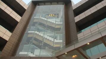 A modern building with a glass facade, a visible staircase, and a sign with 'H2' on it.