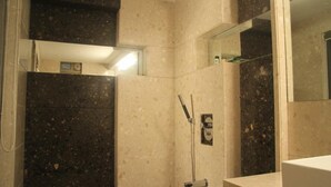 A bathroom with a shower, a mirror, and a towel rack. - Beacon T2 Mumbai (Mumbai)