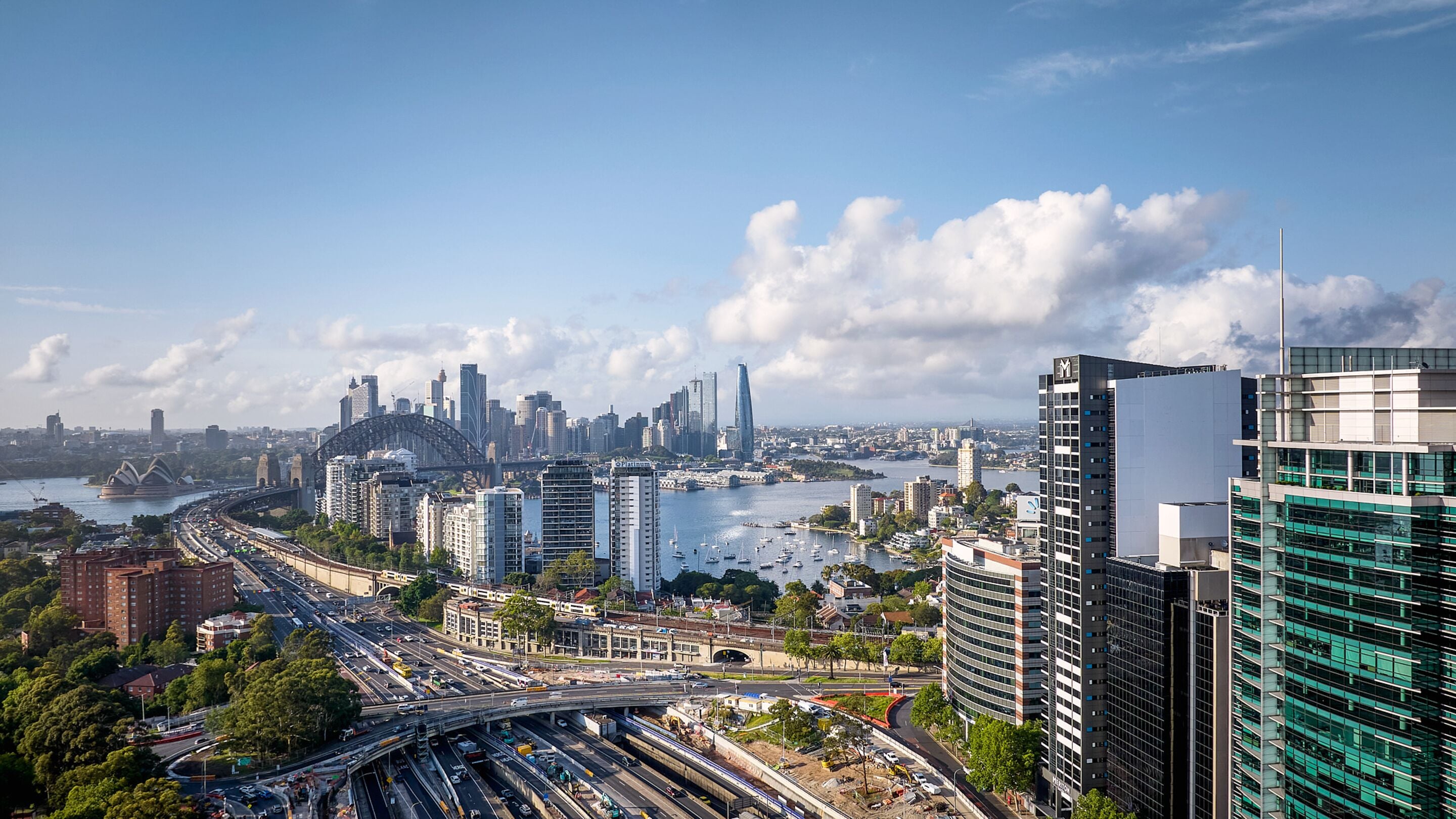 A cityscape with modern buildings, a bridge, and a river.