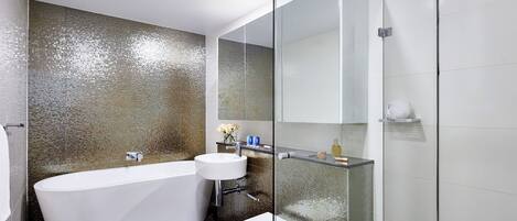 A modern bathroom with a freestanding bathtub, a toilet, and a glass-enclosed shower area.