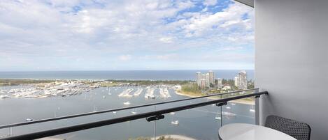 A balcony with a view of a marina and buildings across the water.