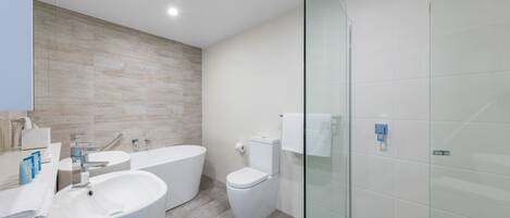 Un baño moderno con un lavamanos grande, una bañera y un inodoro.