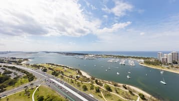 Vue aérienne d’une ville côtière avec un port de plaisance, des routes et des espaces verts.