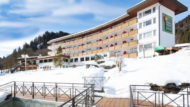 A multi-story hotel with a modern design, featuring a prominent entrance and a ski lift visible in the background. - Alpenhotel Oberstdorf (Oberstdorf)