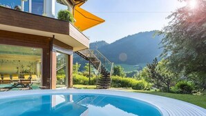 A modern pool area with a clear view of the mountains in the background. - Alpenhotel Oberstdorf (Oberstdorf)