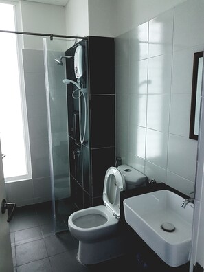 A modern bathroom with a glass-enclosed shower, a toilet, and a bathtub. - Holi 1Medini Suites (Iskandar Puteri)