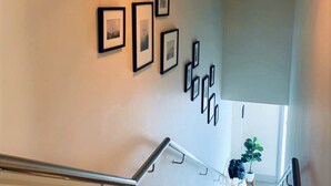 Una escalera de diseño moderno, con barandilla de metal y piso de madera.
