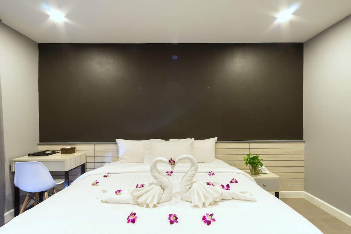 Une chambre d’hôtel avec un lit bien fait, un bureau et une chaise.