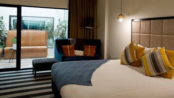 Una habitación de hotel con cama, una silla, un ventanal y vistas al exterior.