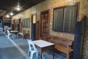 A room with a long table and chairs, wooden benches, and a large window. - Love S Beach And Dive Resort (Moalboal)
