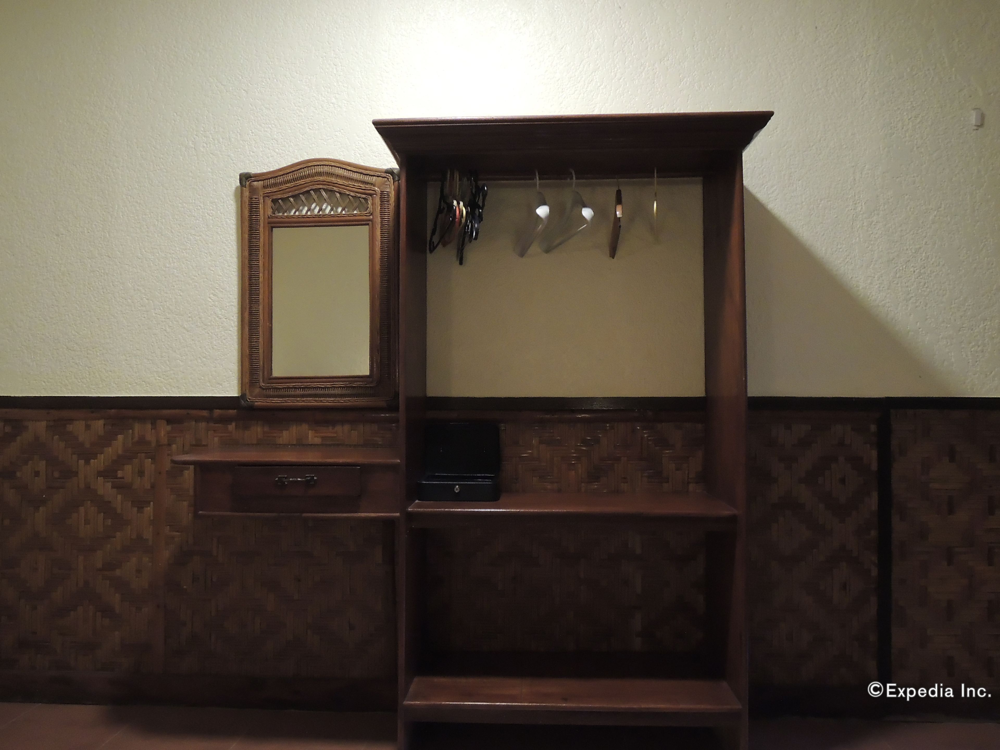 A wooden vanity with a mirror and a shelf.