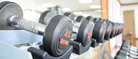 Eine Reihe von Gewichtsplatten an einem Gewichtsständer in einem Fitnessstudio.