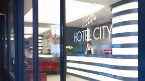 Un espace d’accueil d’hôtel au design moderne, comprenant un comptoir d’accueil et un coin salon.
