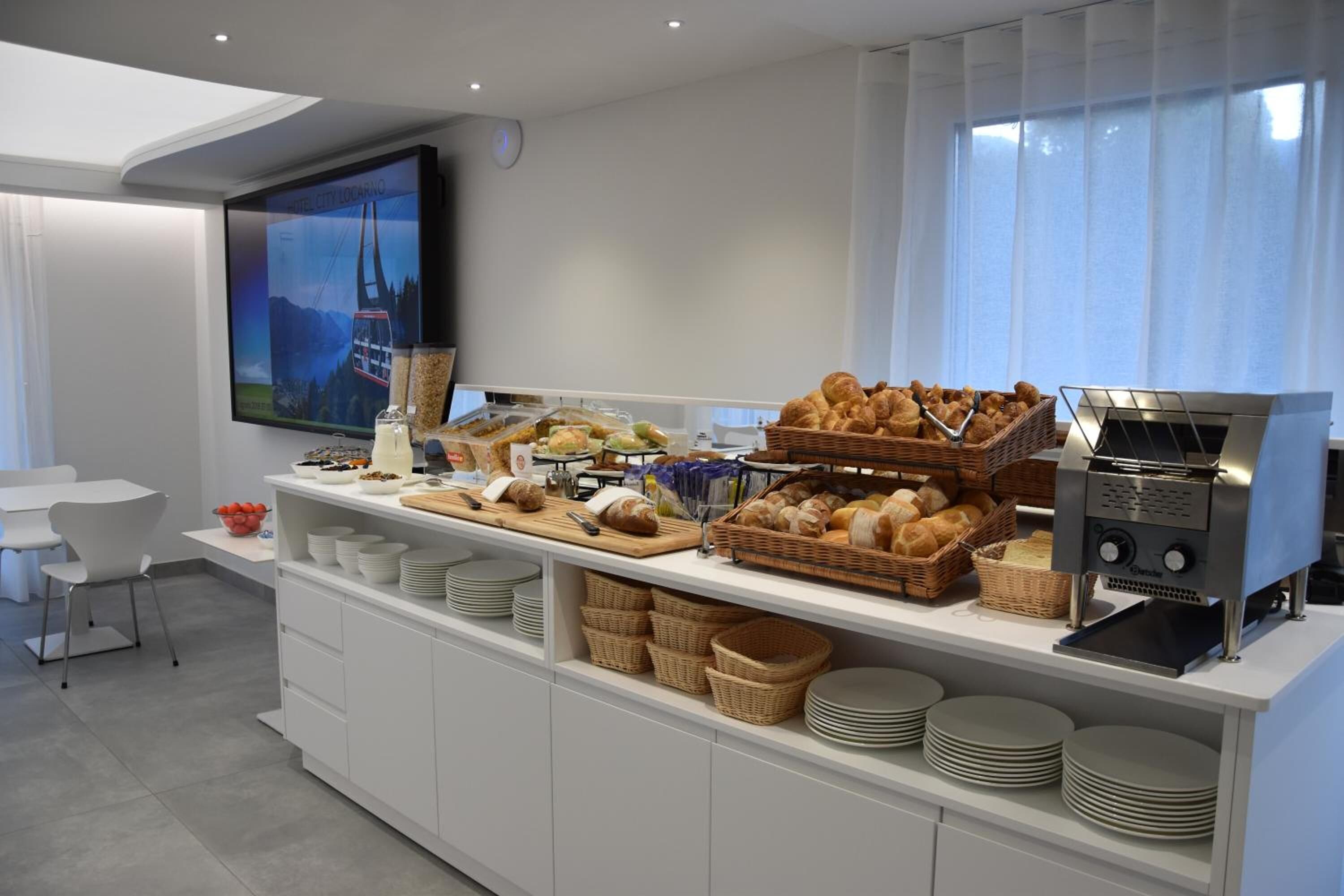 Un ricco buffet per la colazione con diversi tipi di pane, dolci e una macchina del caffè.