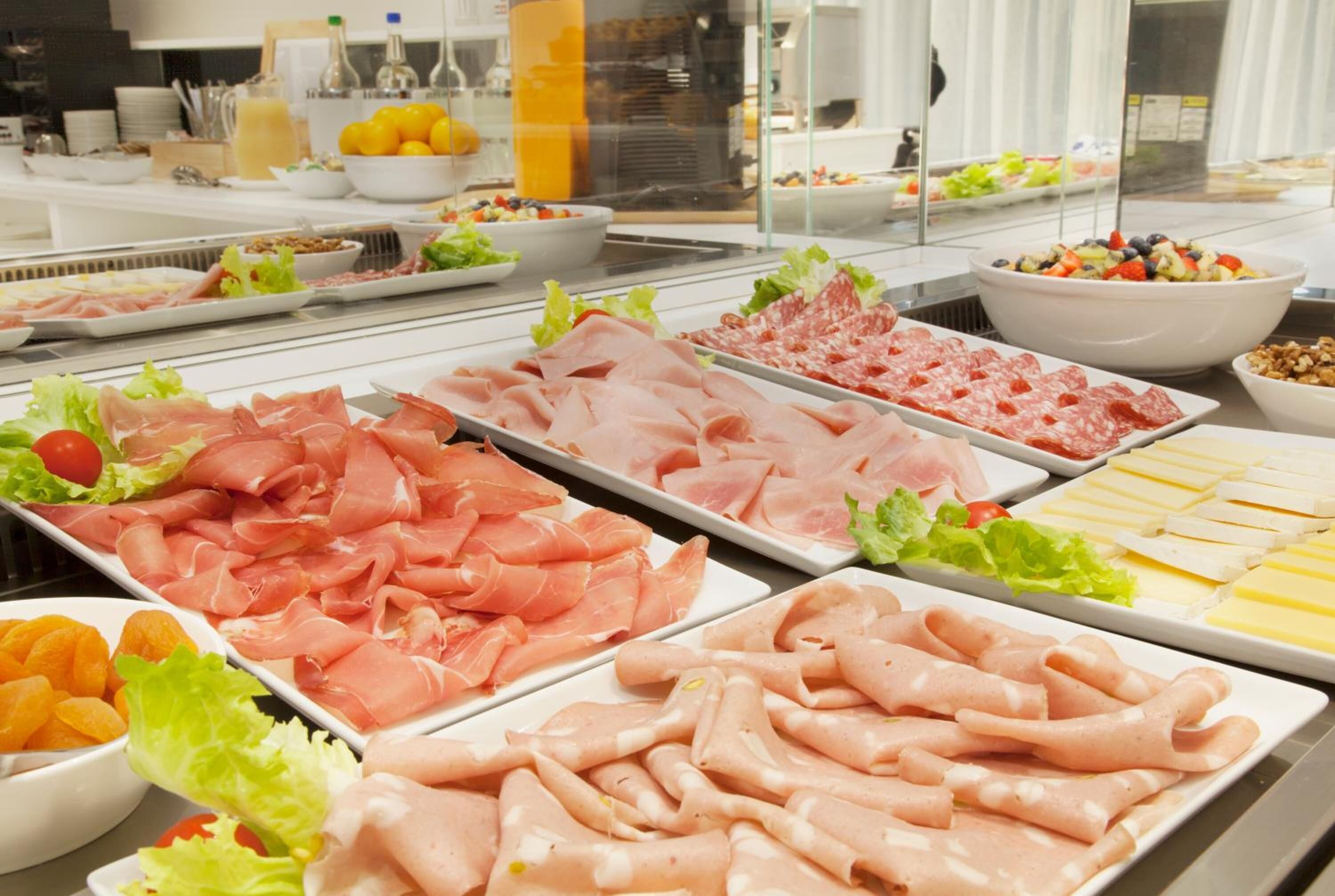 A buffet with various meats and cheeses.