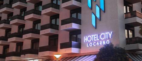 Un edificio de hotel de varios pisos con un logotipo y señalización destacados.