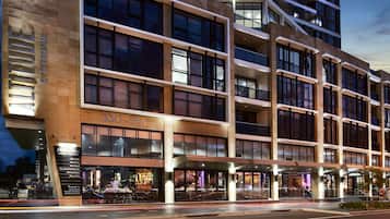 A multi-story hotel with a modern facade, large windows, and a ground-level restaurant.