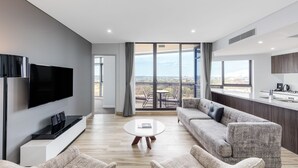 Una sala de estar moderna con un televisor de pantalla plana, una mesa de centro y un sofá.