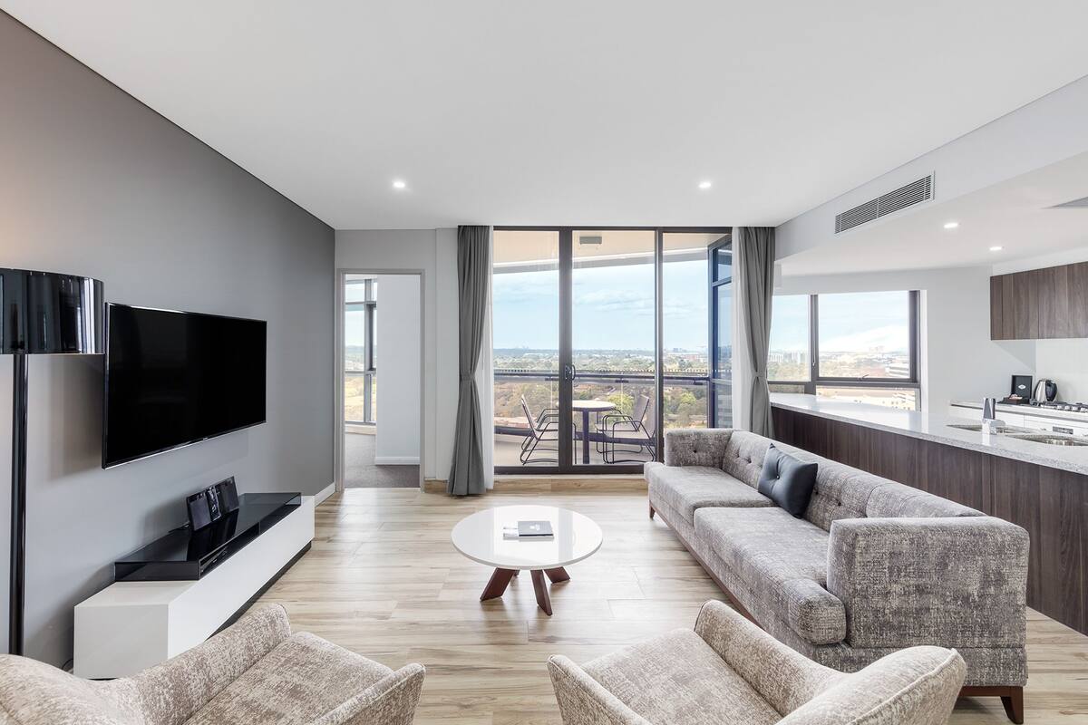 Ein modernes Wohnzimmer mit Flachbildfernseher, Couchtisch und Sofa.