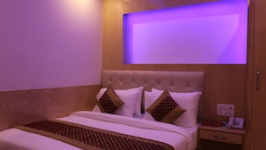 Ein Hotelzimmer mit einem Bett, einem Nachttisch und einem an der Wand befestigten Fernseher.
