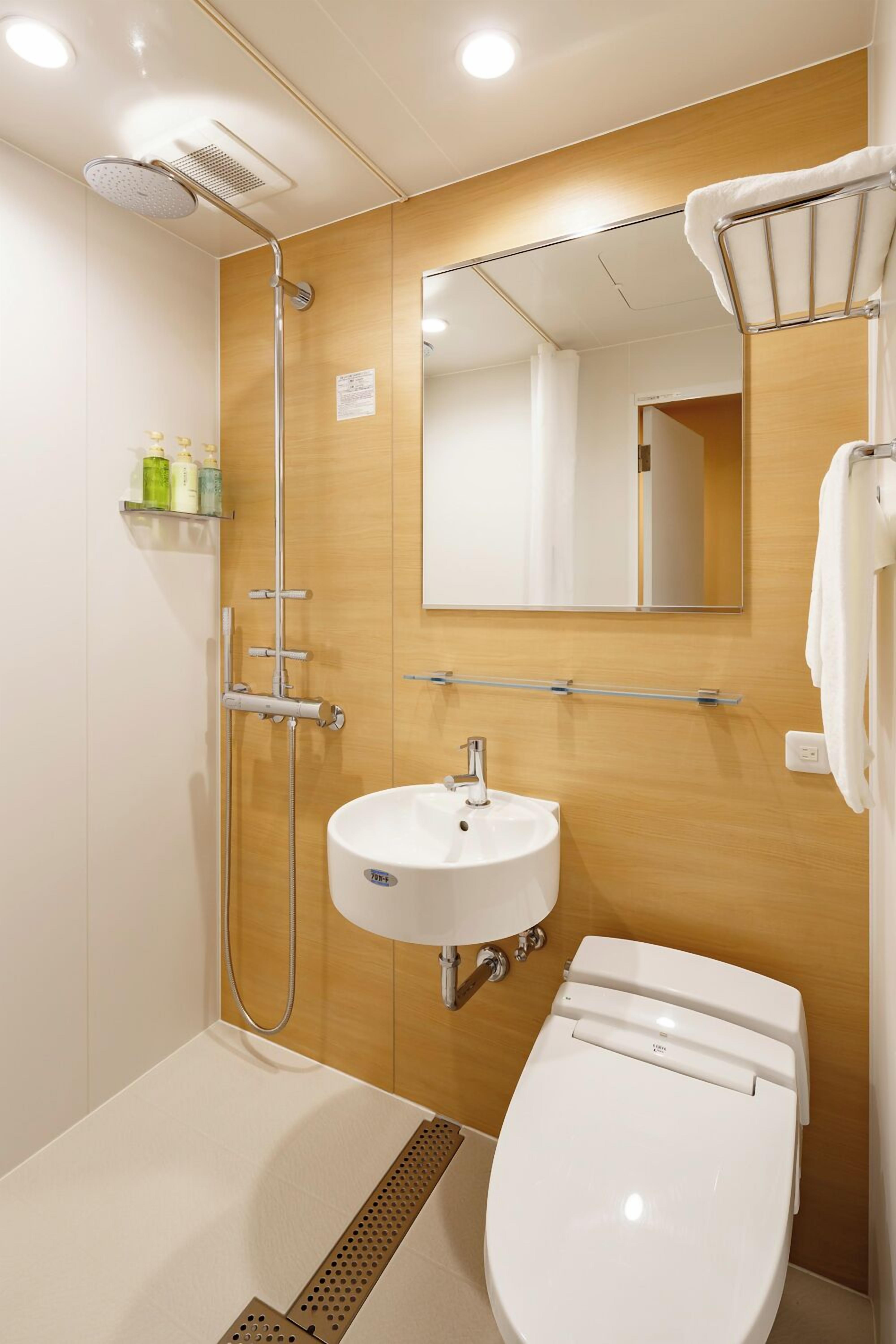 Une salle de bain moderne équipée d’une douche, d’un lavabo et de toilettes.