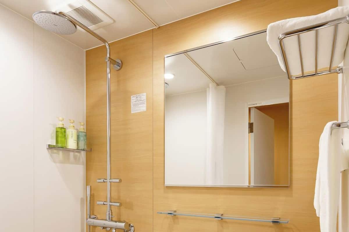 A modern bathroom with a shower, sink, and toilet.