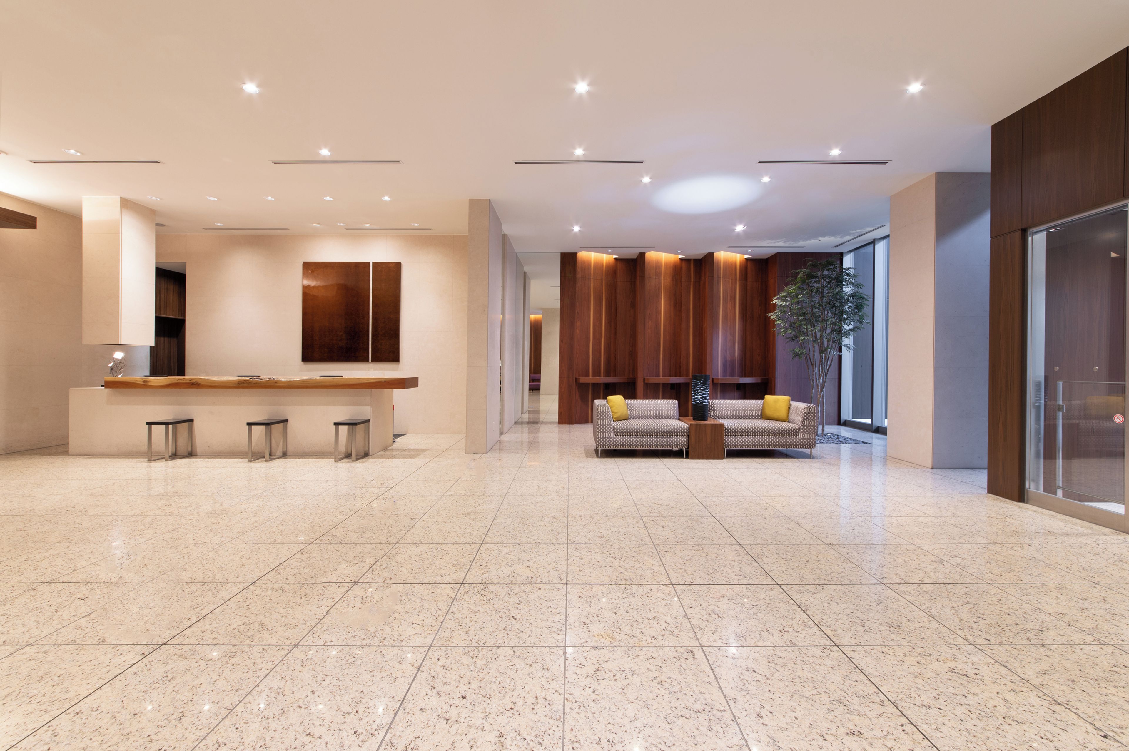 A spacious lobby with a reception desk, seating area, and a large window.