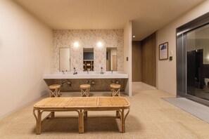 A bathroom with a large mirror, three sinks, and a bench. - Hotel Vista Sendai (Sendai)