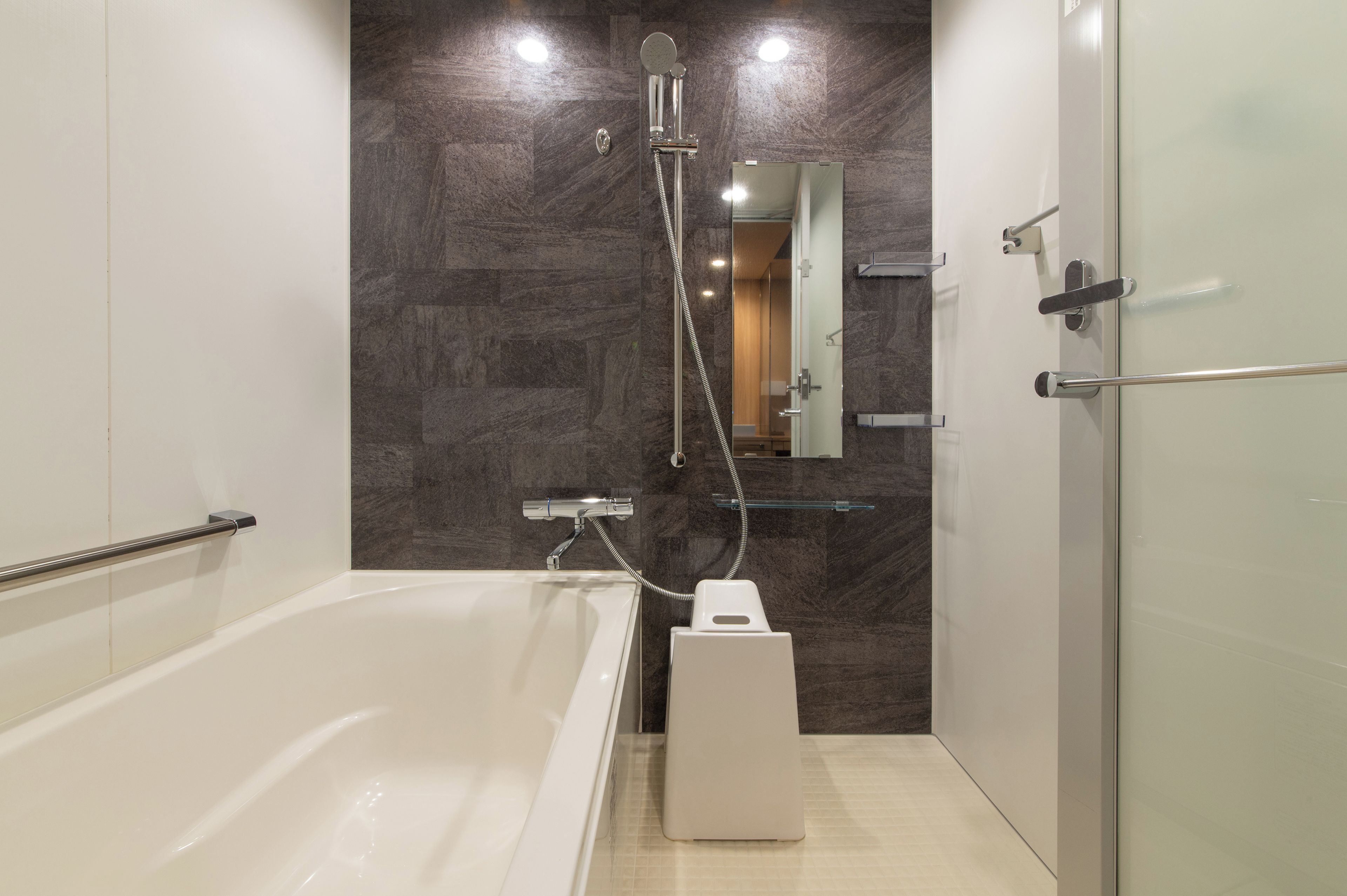A modern bathroom with a bathtub, a shower, and a glass-enclosed shower area.