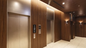 A modern elevator interior with wooden paneling and a tiled floor. - Hotel Vista Sendai (Sendai)