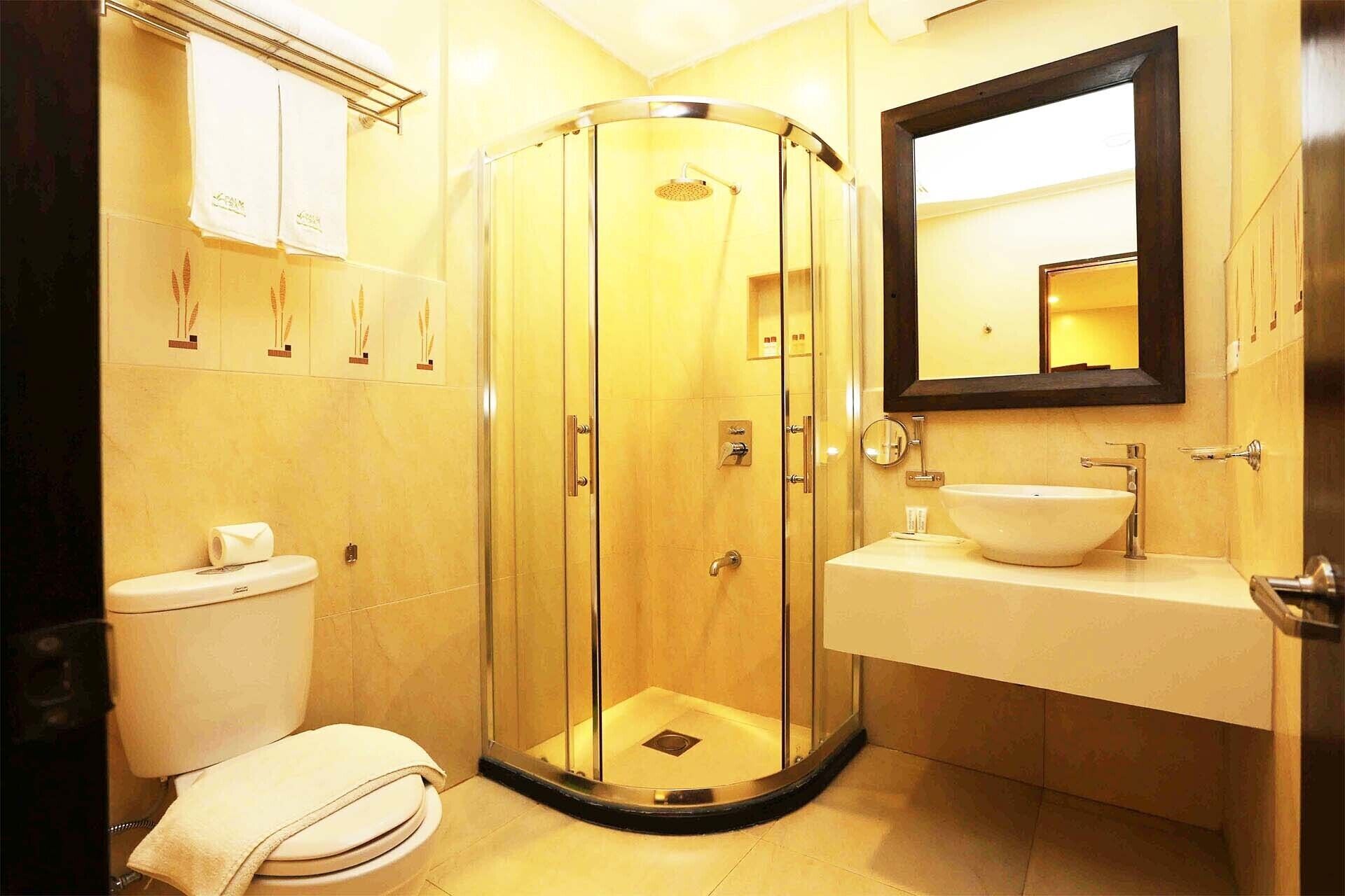 A modern bathroom with a glass-enclosed shower, a white sink, and a toilet.