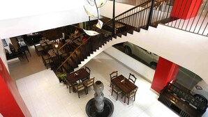 A multi-level interior with a staircase, dining area, and a central decorative feature.