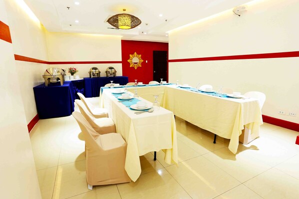 A conference room with tables set for a meeting, equipped with nameplates, water bottles, and a clock on the wall. - Palm Grass Hotel (Cebu City)