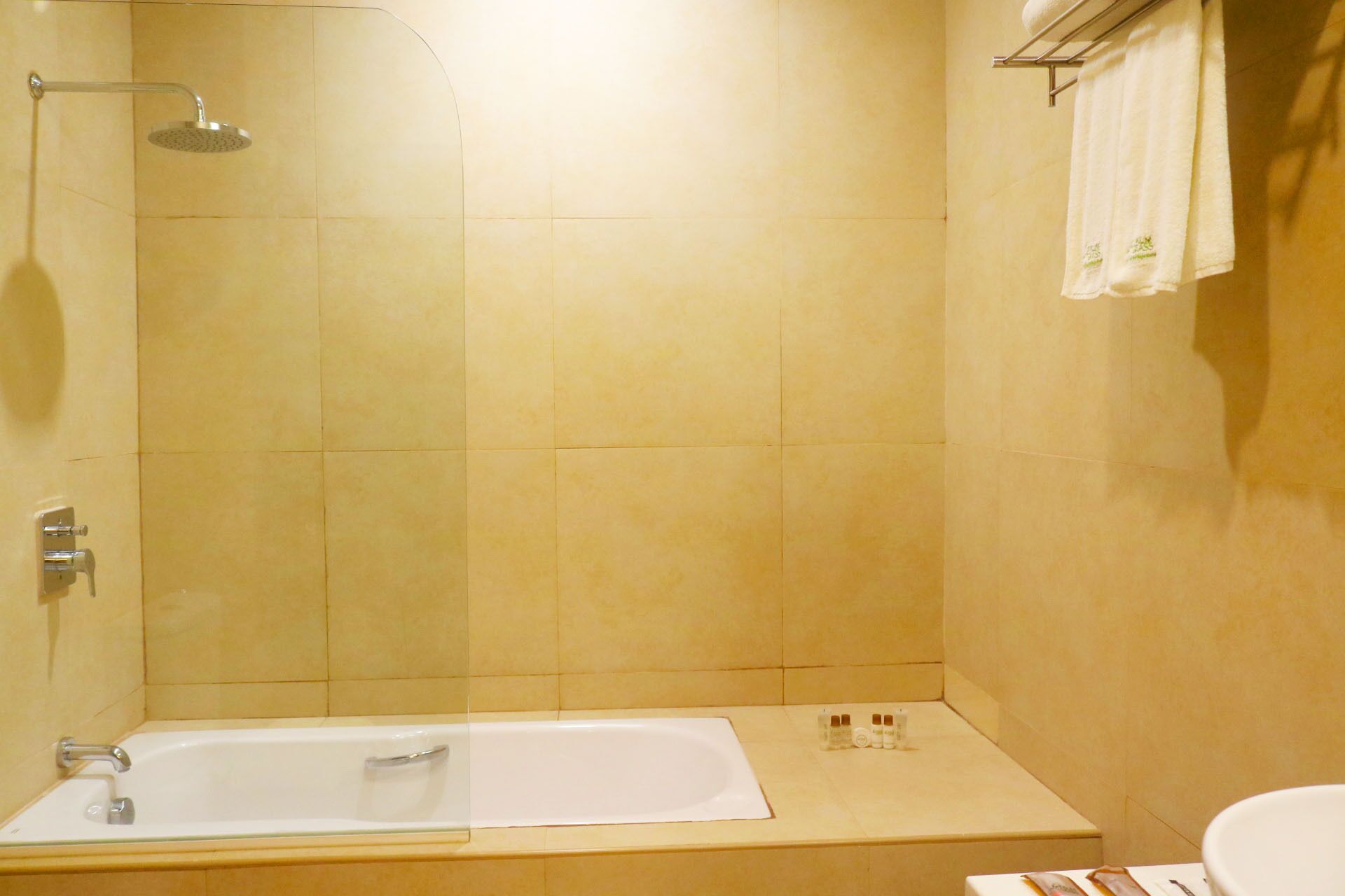 Un baño con bañera, ducha y barra para toallas.