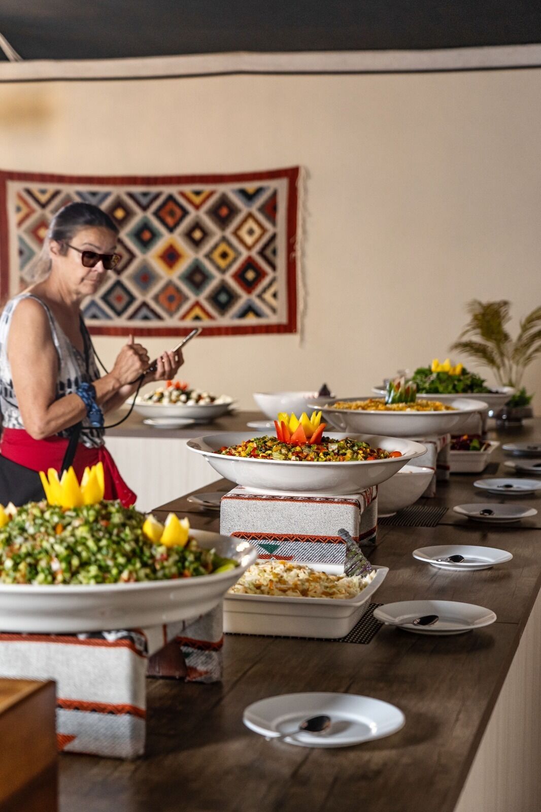 A buffet table with various dishes and a person serving.