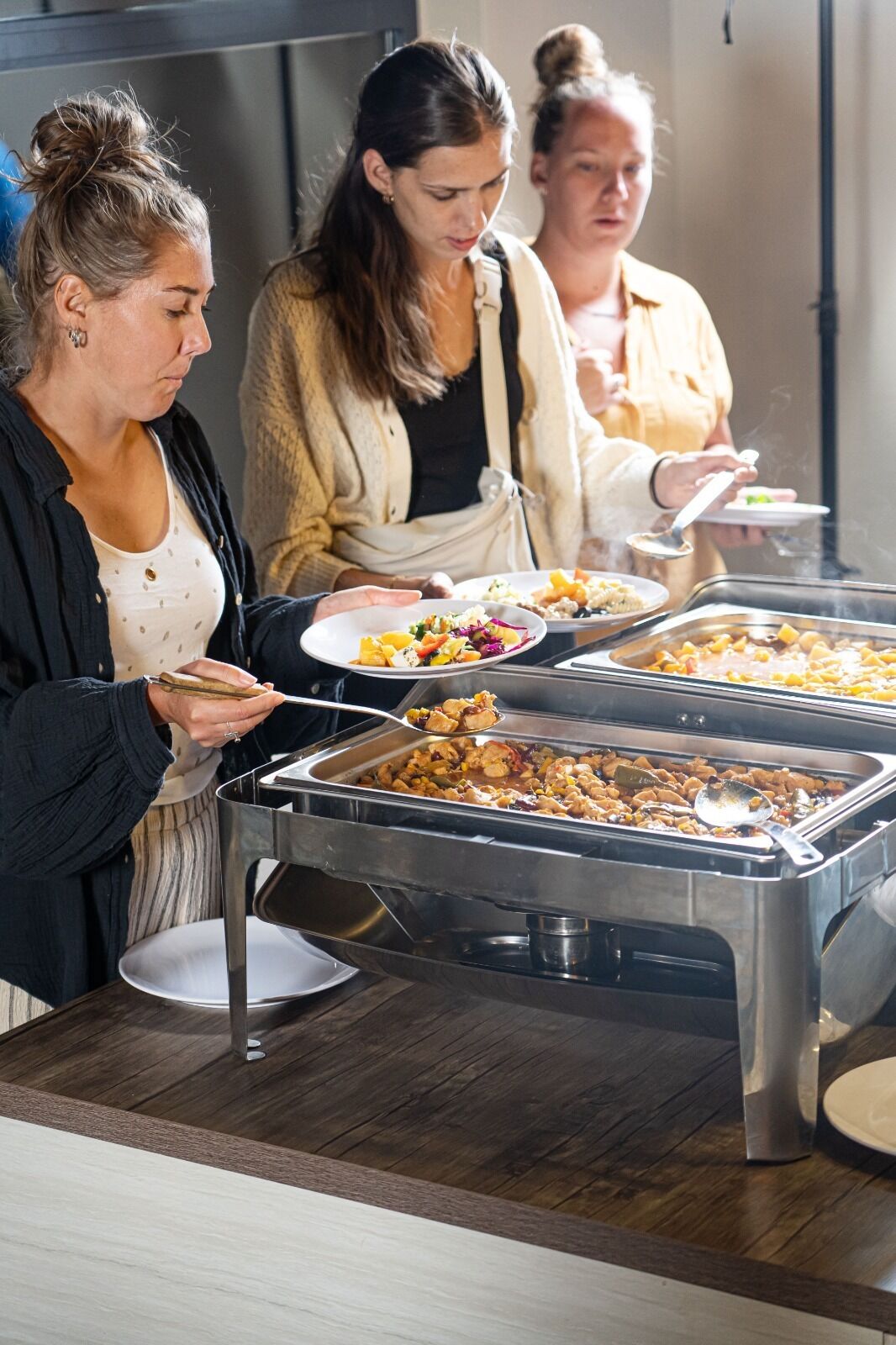 Een buffetopstelling met meerdere serveerschaaltjes en diverse soorten eten.