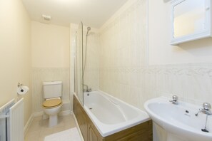 Un baño con inodoro, bañera y lavamanos.