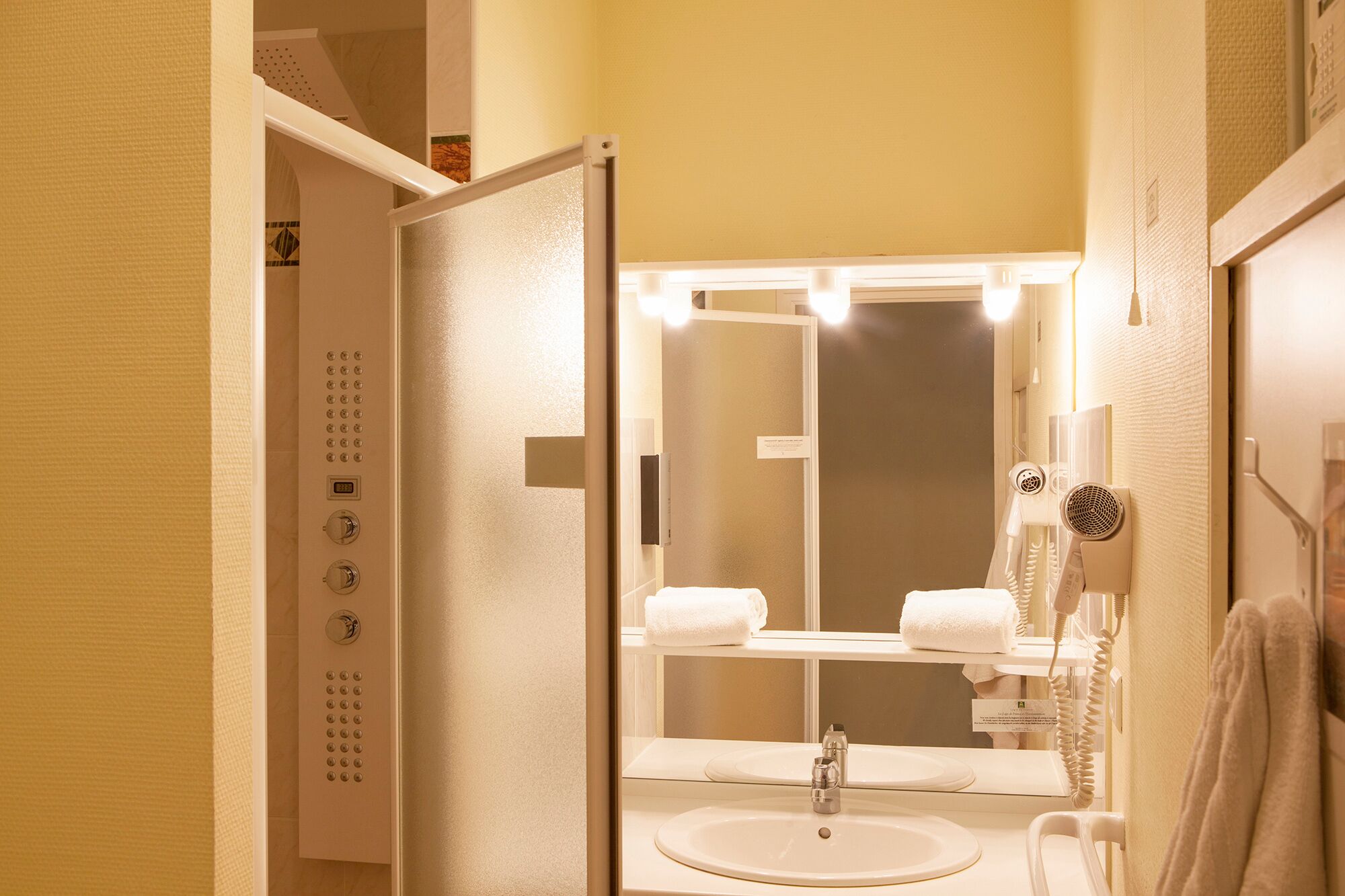 A bathroom with a sink, mirror, towel rack, and a hairdryer.