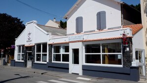 A white building with a sign reading "Le Petit Bistro" and "Hotel". - Hôtel le Petit Trianon (Saint-Brevin-les-Pins)