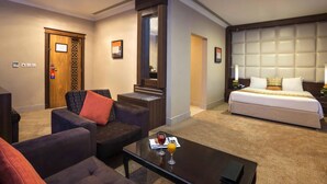 Ein Hotelzimmer mit Bett, Sofa, Couchtisch und Schreibtisch.
